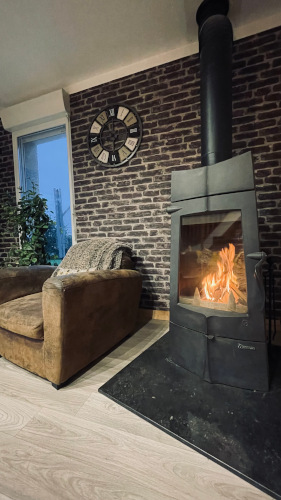 Poêle à bois en route, à côté d'un fauteuil marron